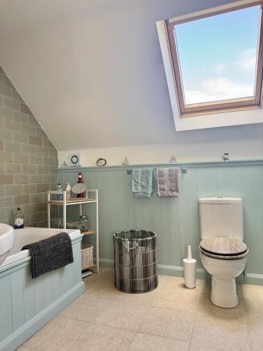 a bathroom with a toilet and a tub and a window at Charming Dog-Friendly Guesthouse in Sidbury