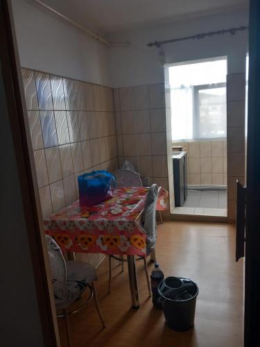 una stanza con tavolo, sedie e cucina di Apartament a Curtea de Argeş