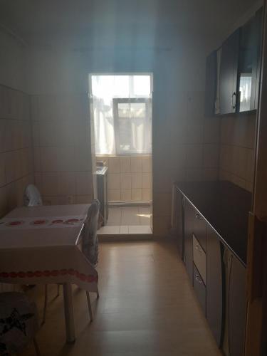 una piccola stanza con un letto e una finestra di Apartament a Curtea de Argeş