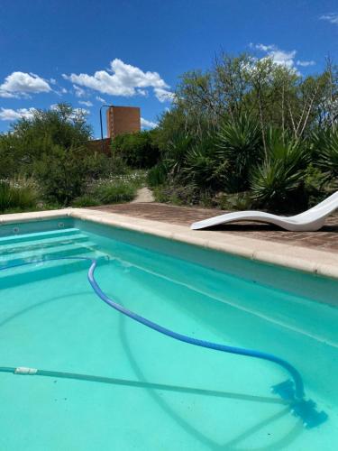 een zwembad met een ligstoel en een slang bij Las estrellas in Las Tapias