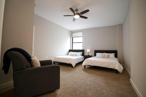 Spacious Downtown Sq Stadium, Casino, R&R HoF! في كليفلاند: غرفة نوم بها سريرين ومروحة سقف