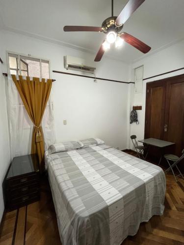 Obelisco Buenos Aires في بوينس آيرس: غرفة نوم بها سرير ومروحة سقف