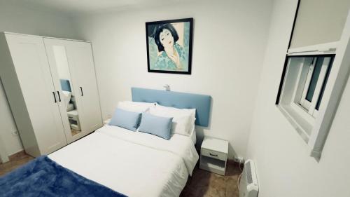 un pequeño dormitorio con una cama y una pintura en la pared en La Casita de Toñita, en Valdoviño