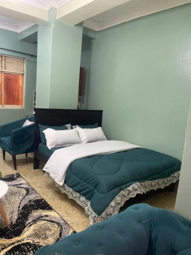 une chambre avec un grand lit et un canapé dans l'établissement Hella home, à Kampala