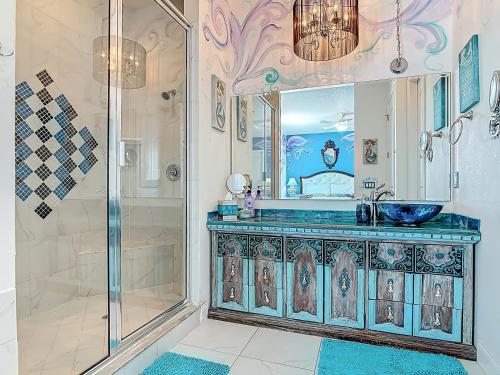 a bathroom with a blue sink and a shower at Inn on the Avenue in New Smyrna Beach