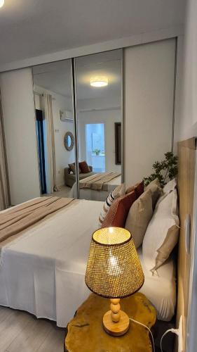 a bedroom with a large bed and a table with a lamp at kriola Breeze in Praia