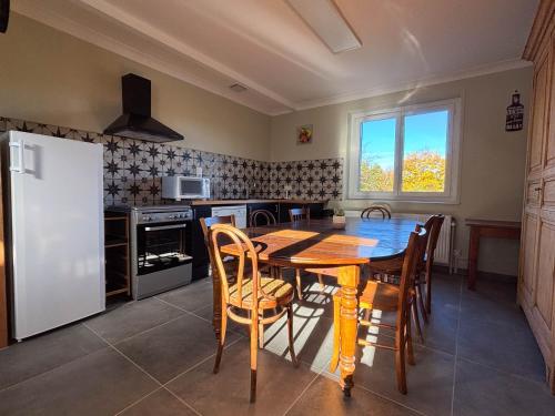 a kitchen with a table and chairs and a refrigerator at Les chambres de Marie in Villié-Morgon