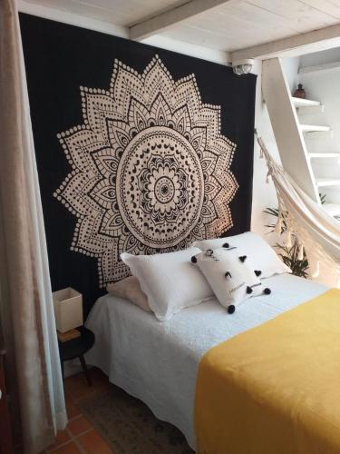 a bedroom with a mandala mural on the wall at Sambaqui - Casa de Hóspedes Kitinet in Florianópolis