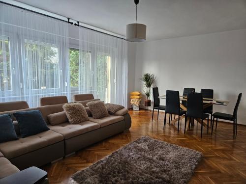 a living room with a couch and a dining room at FAMILLE Apartman in Tapolca