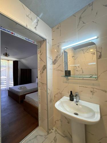 a bathroom with a sink and a mirror and a bedroom at Lagusheda in Nashtkoli