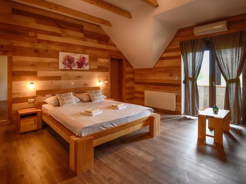 a bedroom with a bed in a room with wooden walls at Villa Stone in Rakovica