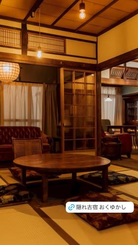 a living room with a wooden table and chairs at 隠れ古宿 おくゆかし in Beppu