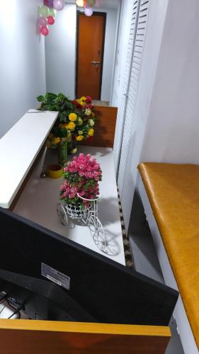 een bureau met een kar met bloemen erop bij Banani Luxury Guest House in Dhaka