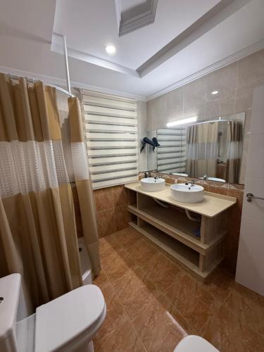 Un baño con dos lavabos, un inodoro y un espejo. en ALOJAMIENTO Rural AVD SIERRA MÁGINA, en Carchelejo