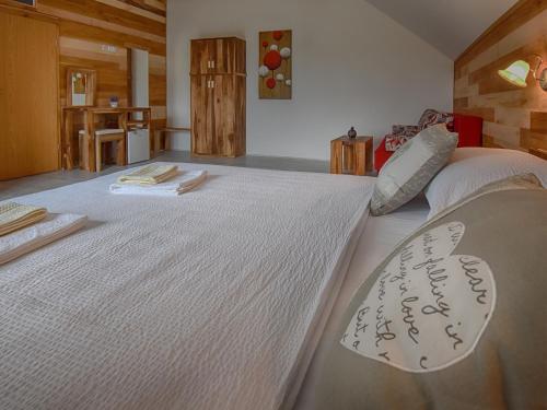 a bedroom with a large white bed with writing on it at Villa Stone in Rakovica
