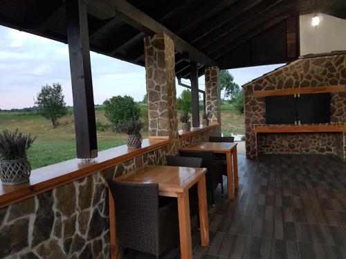 a patio with tables and chairs and a stone wall at Villa Stone in Rakovica