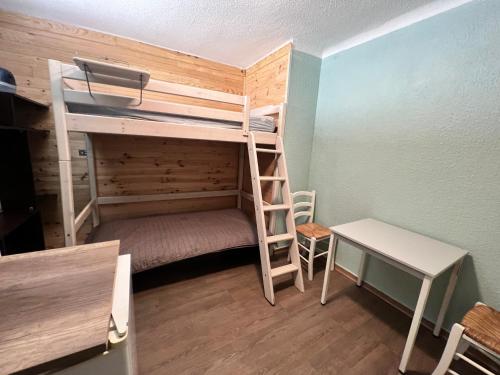 a bunk bed with a ladder and a desk in a room at Studio centre-ville in Cluses
