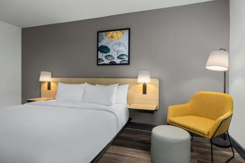 a hotel room with a bed and a chair at City Express by Marriott Yulee in Yulee