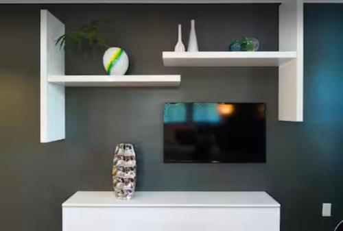 a living room with white shelves on a wall at Village District Condo in Raleigh