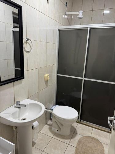 ein Badezimmer mit Toilette, Dusche und Waschbecken in der Unterkunft Apart CENTRO in Tubarão