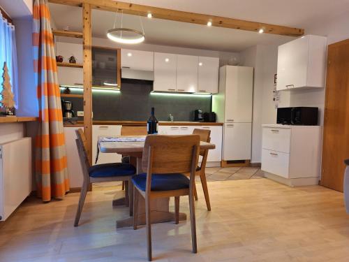 a kitchen with a dining room table and chairs at Apartments Insam in Santa Cristina in Val Gardena