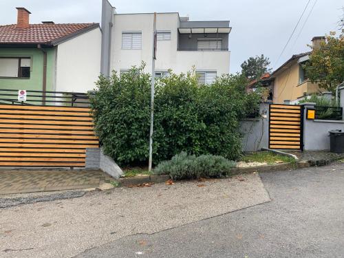 a house with a wooden fence next to a street at Aura in Kumanovo