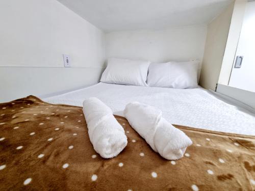 uma cama com duas toalhas enroladas no chão em Kitnet Minimalista Mezanino em São Paulo