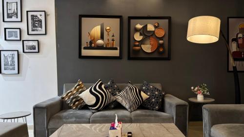 uma sala de estar com um sofá com almofadas em Gold Crest Signature One Bedroom Family Apartments - City View DHA Lahore em Lahore