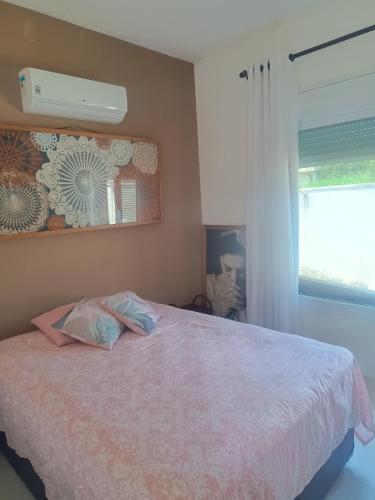 a bedroom with a bed and a window at Casa de Alto Padrão Piscina e Linda Vista para o Mar in Caraguatatuba
