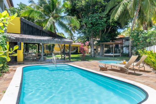 a swimming pool in a yard with a house at Casa a 100 metros do mar- no Centro de Porto de Galinhas in Porto De Galinhas
