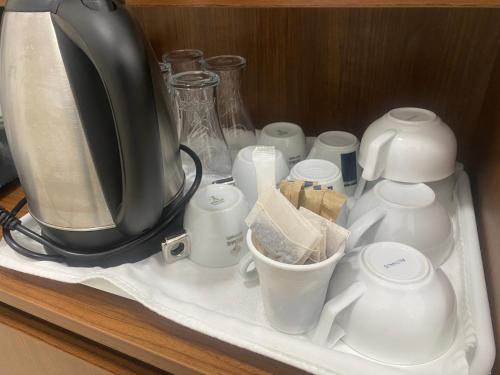 een plank met een koffiezetapparaat en kopjes erop bij TURQUOISE Hostel in Boekarest