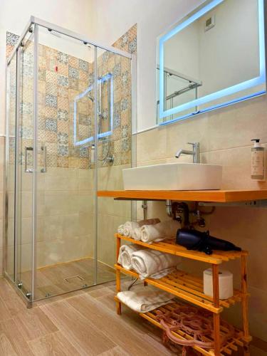 a bathroom with a sink and a glass shower at Il Sogno Siciliano in Mazara del Vallo