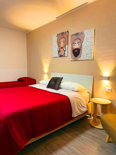 a bedroom with a red bed with two pictures on the wall at Il Sogno Siciliano in Mazara del Vallo