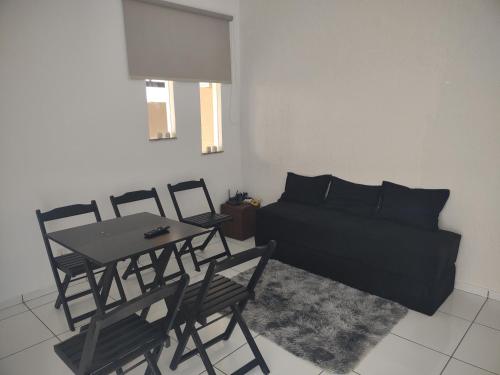 Una sala de estar con una cama, una mesa y sillas. en Casa com 03 Quartos, Piscina e Churrasqueira em Itaipuaçu Maricá RJ, en Maricá