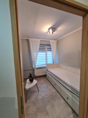 a small room with a bed and a window at Studio pod Śnieżnymi Kotłami in Piechowice