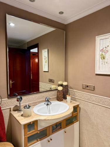 ein Badezimmer mit Waschbecken und großem Spiegel in der Unterkunft Grand Beachfront Apartament - Cadiz in Cádiz