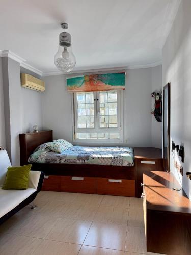 ein Schlafzimmer mit einem Bett und einem Fenster in der Unterkunft Grand Beachfront Apartament - Cadiz in Cádiz