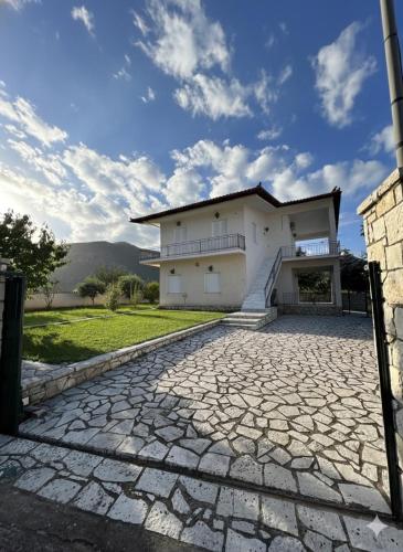 a house with a stone driveway in front of it at Kastellia Horizon Villa in Graviá