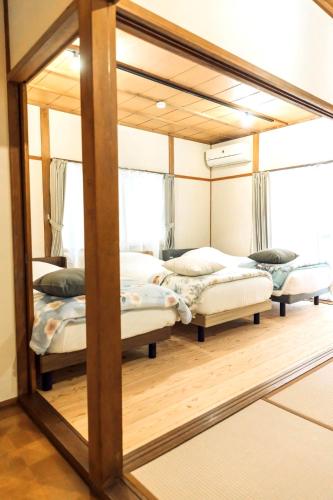 a mirror in a room with four beds at 隠れ古宿 おくゆかし in Beppu