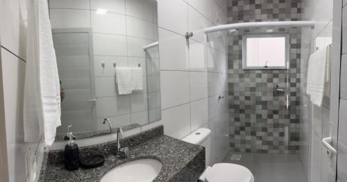 ein Badezimmer mit Waschbecken und Toilette in der Unterkunft Pousada Aloha Pinheira in Palhoça