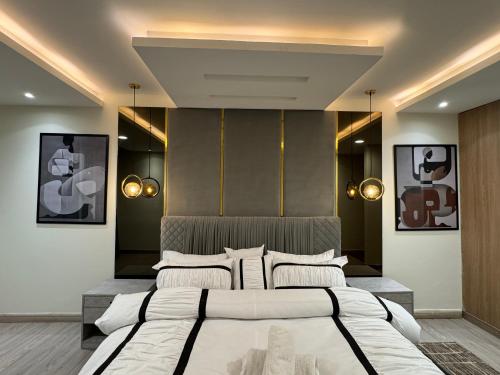 una camera da letto con due letti e due luci sul muro di Gold Crest Signature One Bedroom Family Apartments - City View DHA Lahore a Lahore