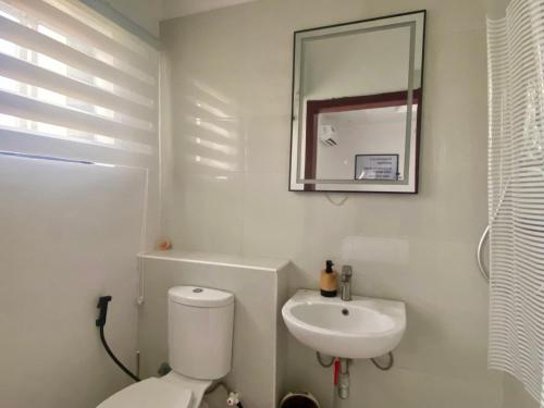a bathroom with a white toilet and a sink at Simplistic Ambience At The Lekki Peninsula, Lagos in Mama