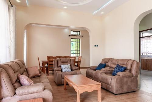a living room with two couches and a table at Ngelenyi Homes in Voi