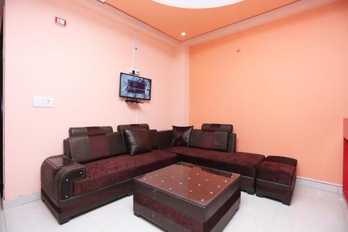 Hotel O Golden Palace في غازي آباد: غرفة معيشة مع أريكة وتلفزيون