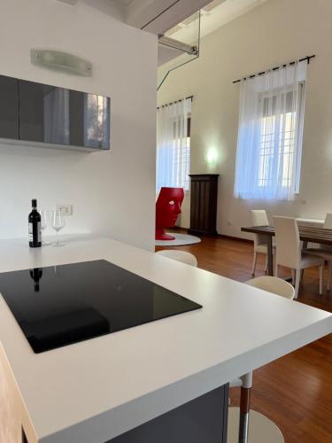 una cucina con piano di lavoro bianco e un soggiorno di LE ORSOLINE Luxury Apartment a Ferrara