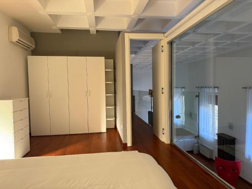 una camera da letto con armadi bianchi e un letto in esso di LE ORSOLINE Luxury Apartment a Ferrara