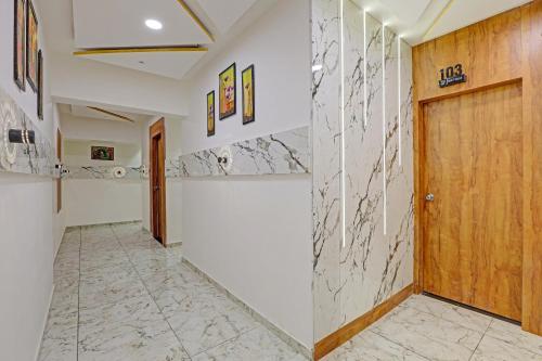 een hal met een houten deur en een tegelvloer bij Hotel O Reet Villa in Ahmedabad