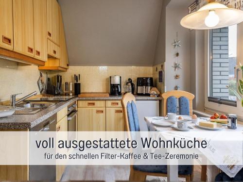 a kitchen with a table and chairs and a kitchen with a table and a kitchen at Ferienwohnung KUMM RIN - Oase an der Nordsee in Carolinensiel