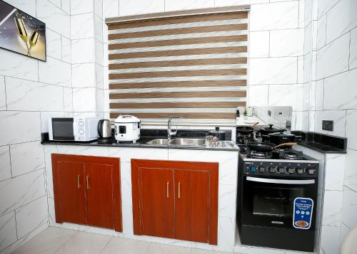 DPE Apartments في كوماسي: مطبخ مع موقد ومغسلة