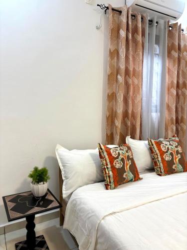 En eller flere senge i et værelse på Modern Cosy 2BR apartment Riviera MBadon